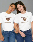 Two people wearing white t-shirts with 'Morning Beans Coastal Dreams' text and heart design.