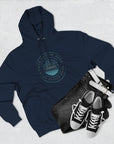 Navy hoodie with a logo, black jeans, and black sneakers on a light gray background
