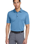 Man wearing a blue polo shirt and gray pants on a white background