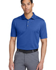 Man wearing a blue polo shirt and gray pants on a white background
