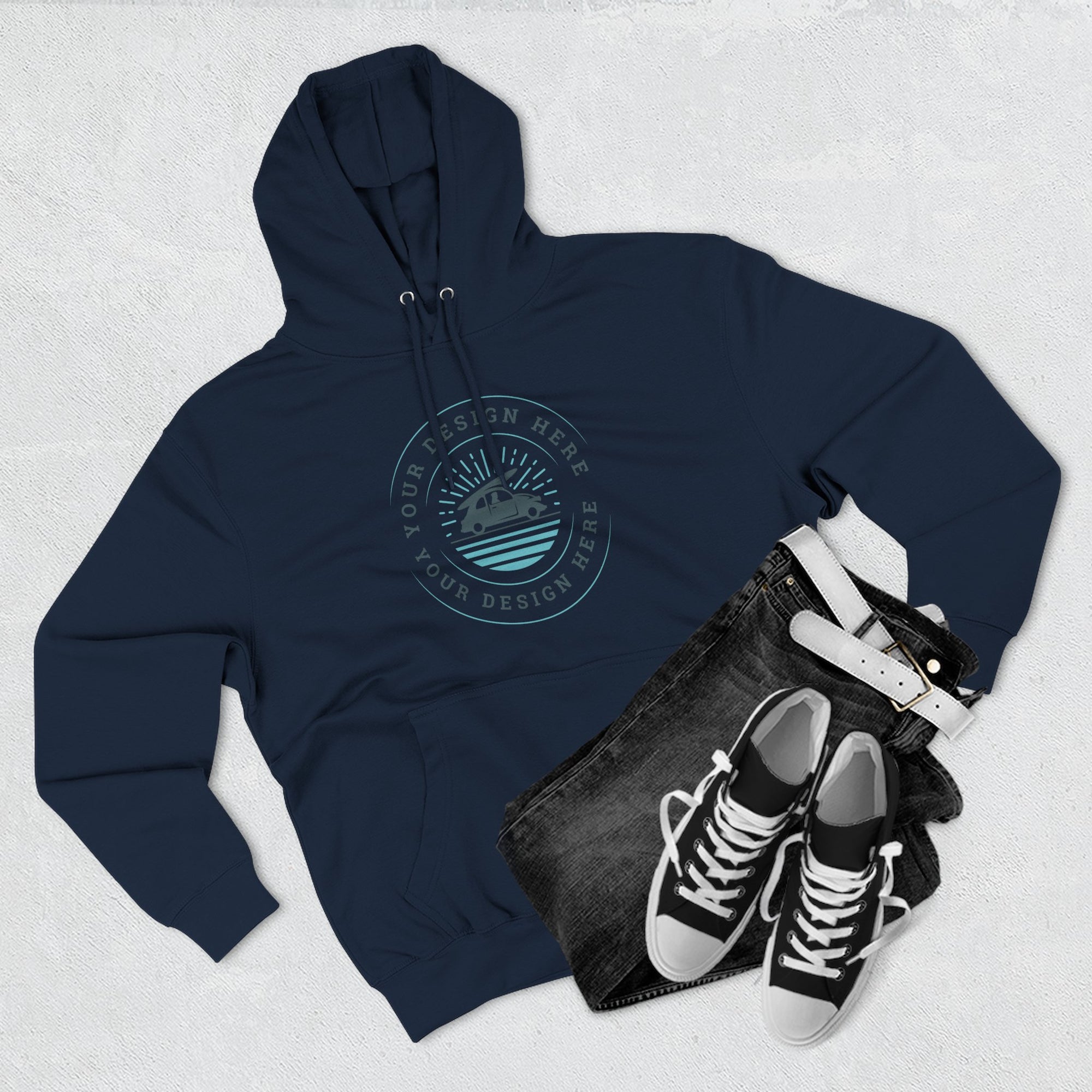 Navy hoodie with a logo, black jeans, and black sneakers on a light gray background