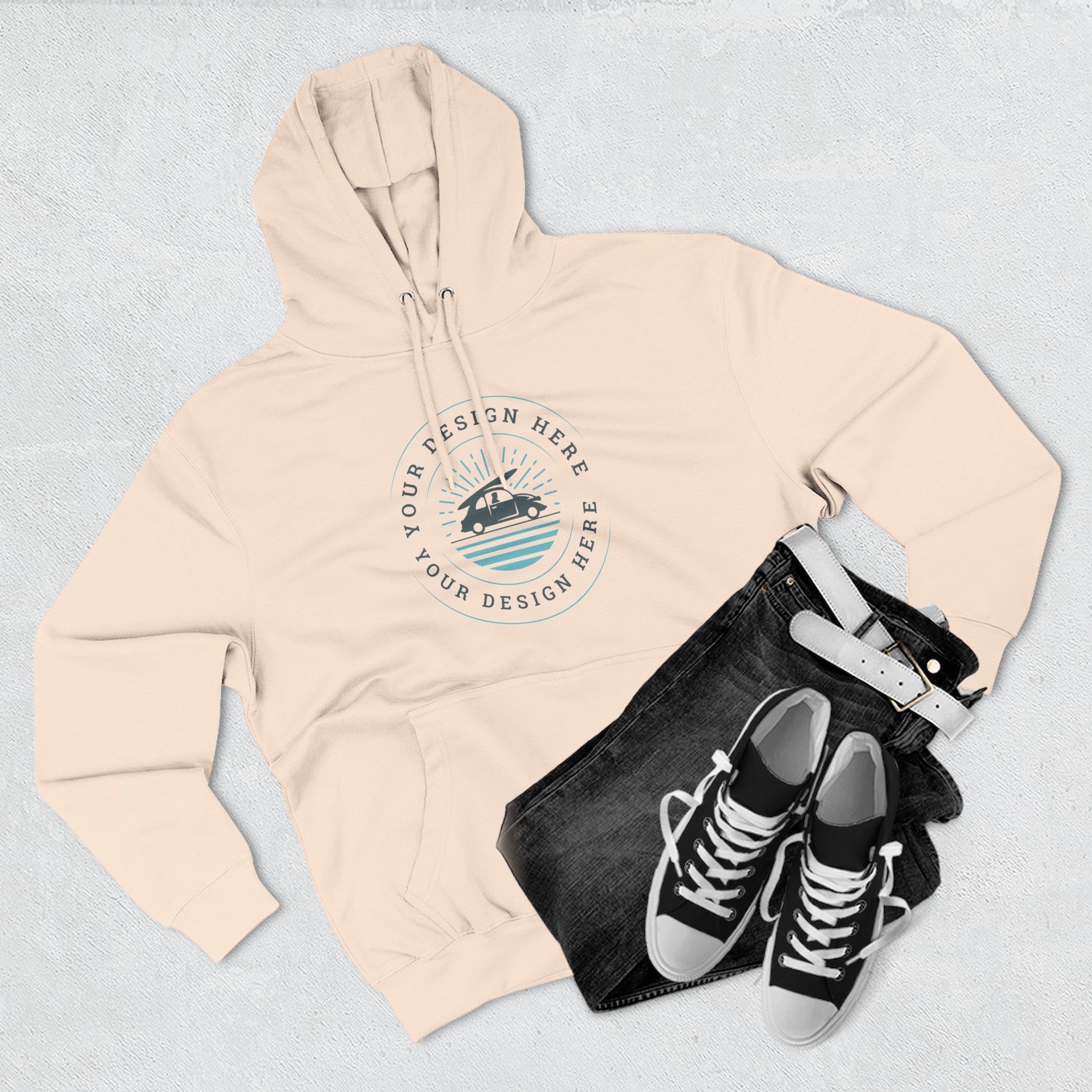 Beige hoodie with a customizable logo design, black pants, and black sneakers on a light gray background