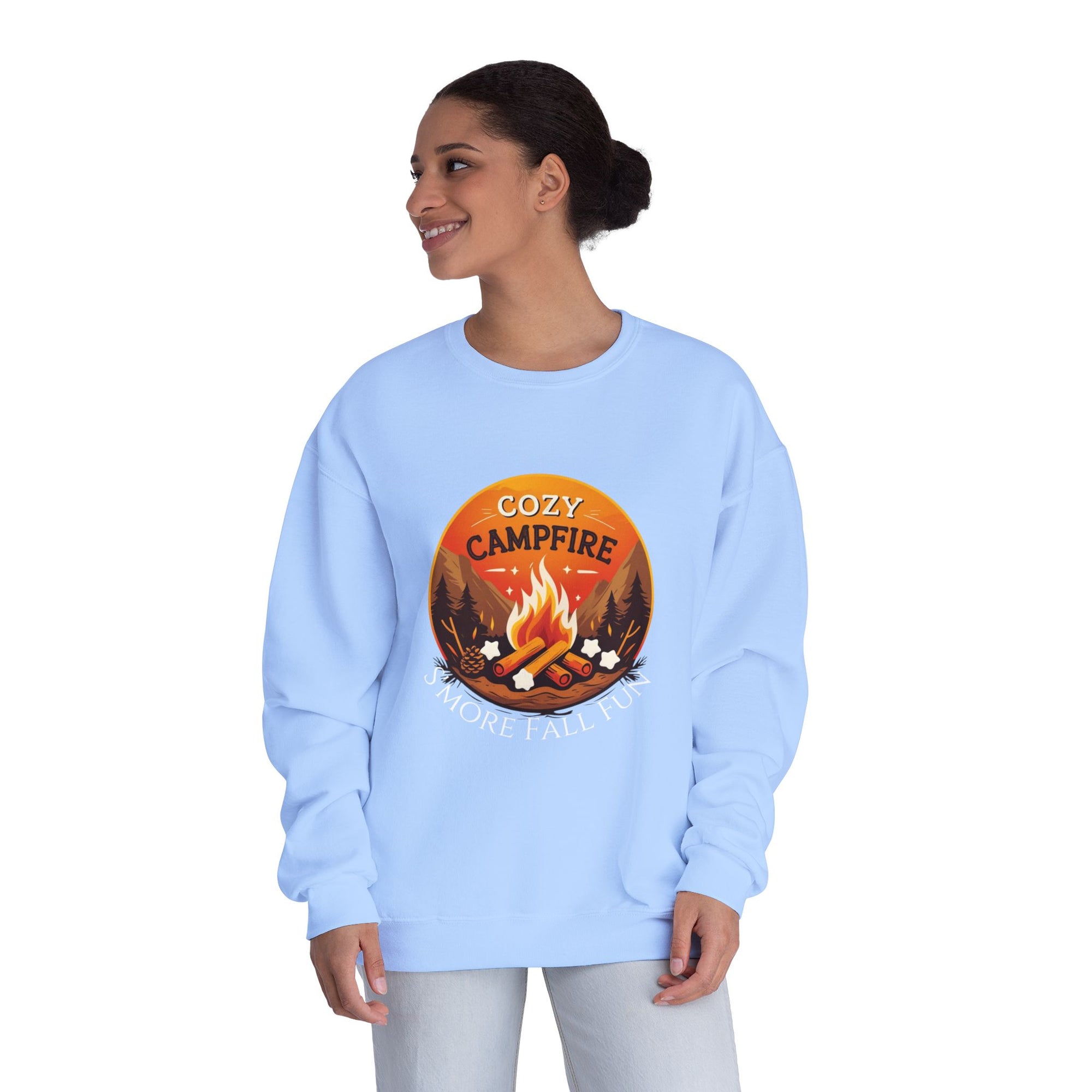 Woman wearing a light blue sweatshirt with a &#39;Cozy Campfire&#39; design on a white background
