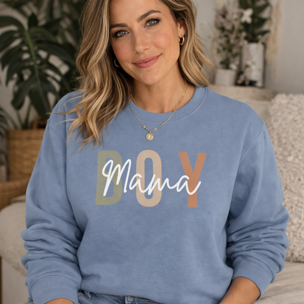 Woman wearing a blue sweatshirt with 'BOY Mama' text in a home setting