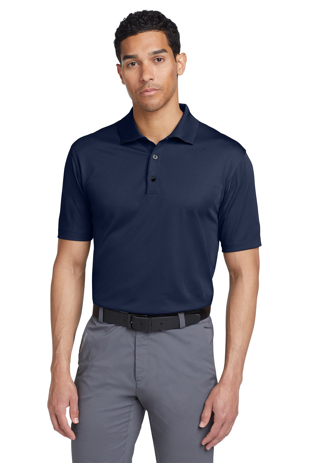 Man wearing a navy polo shirt and gray pants on a white background