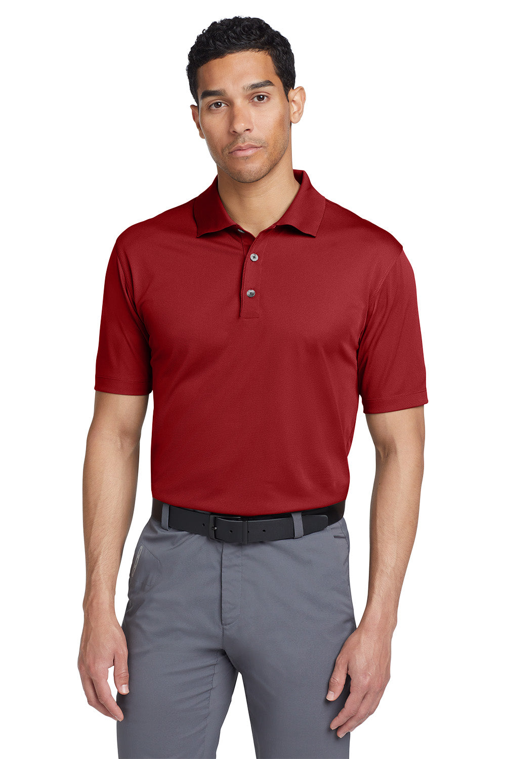 Man wearing a red polo shirt and gray pants on a white background
