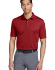 Man wearing a red polo shirt and gray pants on a white background