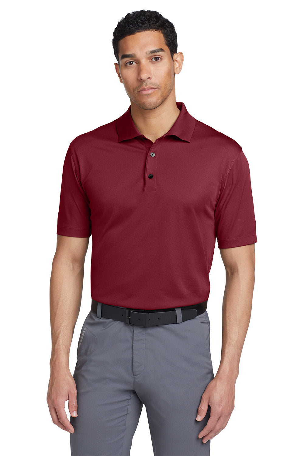 Man wearing a maroon polo shirt and gray pants on a white background