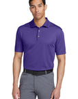 Man wearing a purple polo shirt and gray pants on a white background