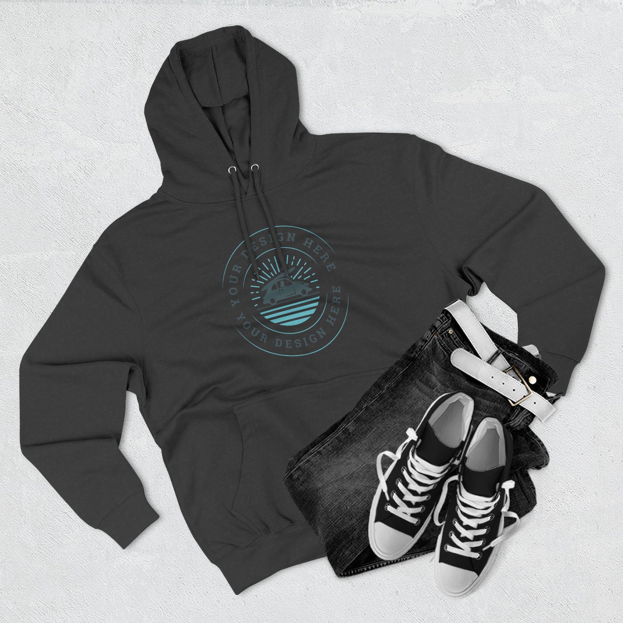 Black hoodie with a design on it, black jeans, and black sneakers on a light gray background