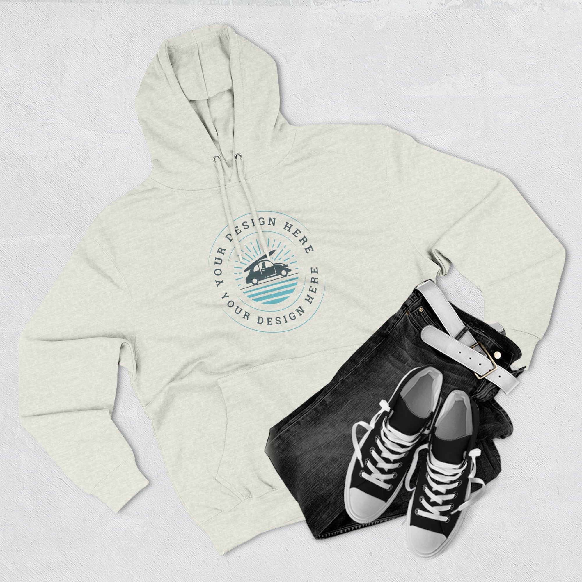 Beige hoodie with a design placeholder, black jeans, and black sneakers on a light gray background