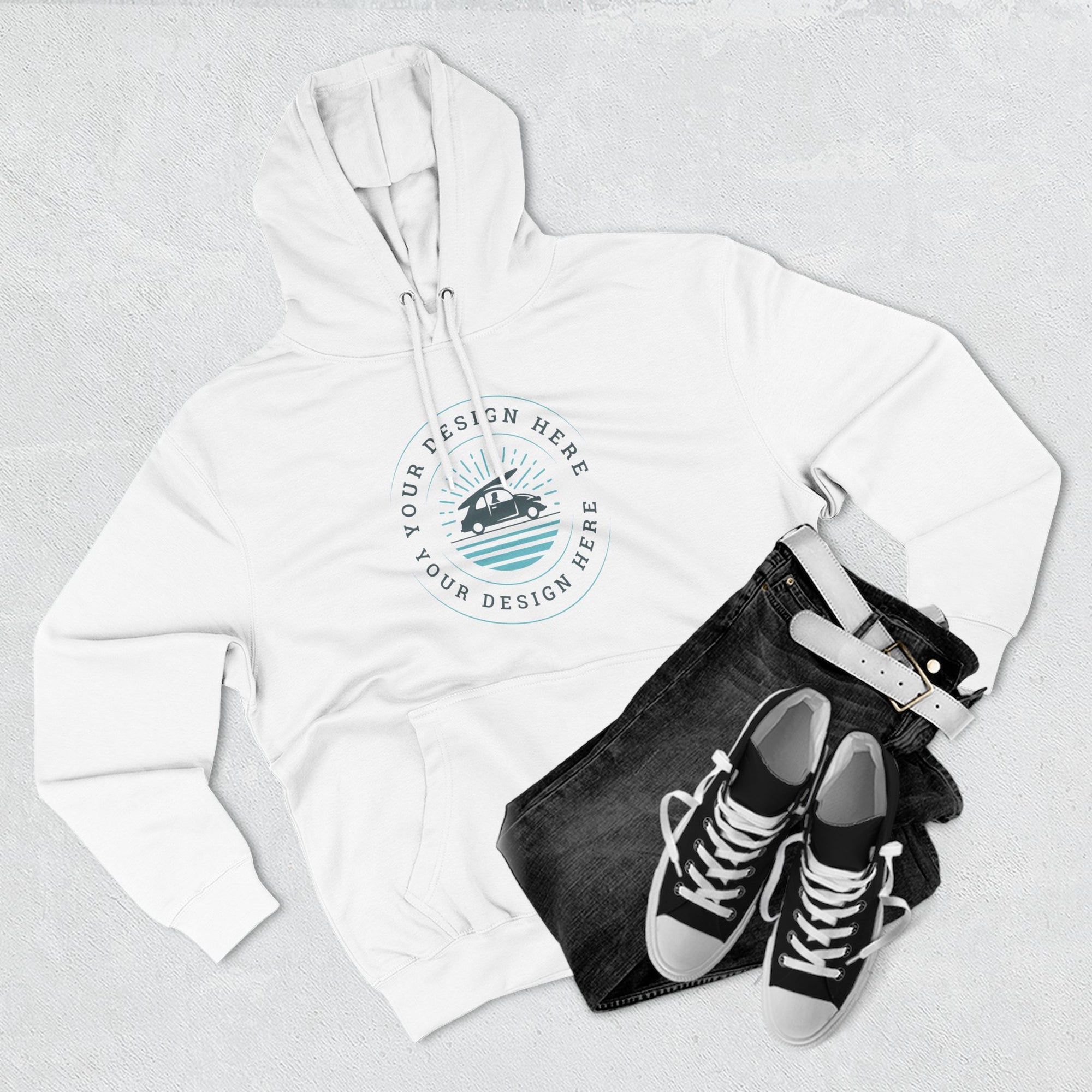 White hoodie with a design placeholder, black jeans, and black sneakers on a light gray background
