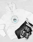 White hoodie with a design placeholder, black jeans, and black sneakers on a light gray background