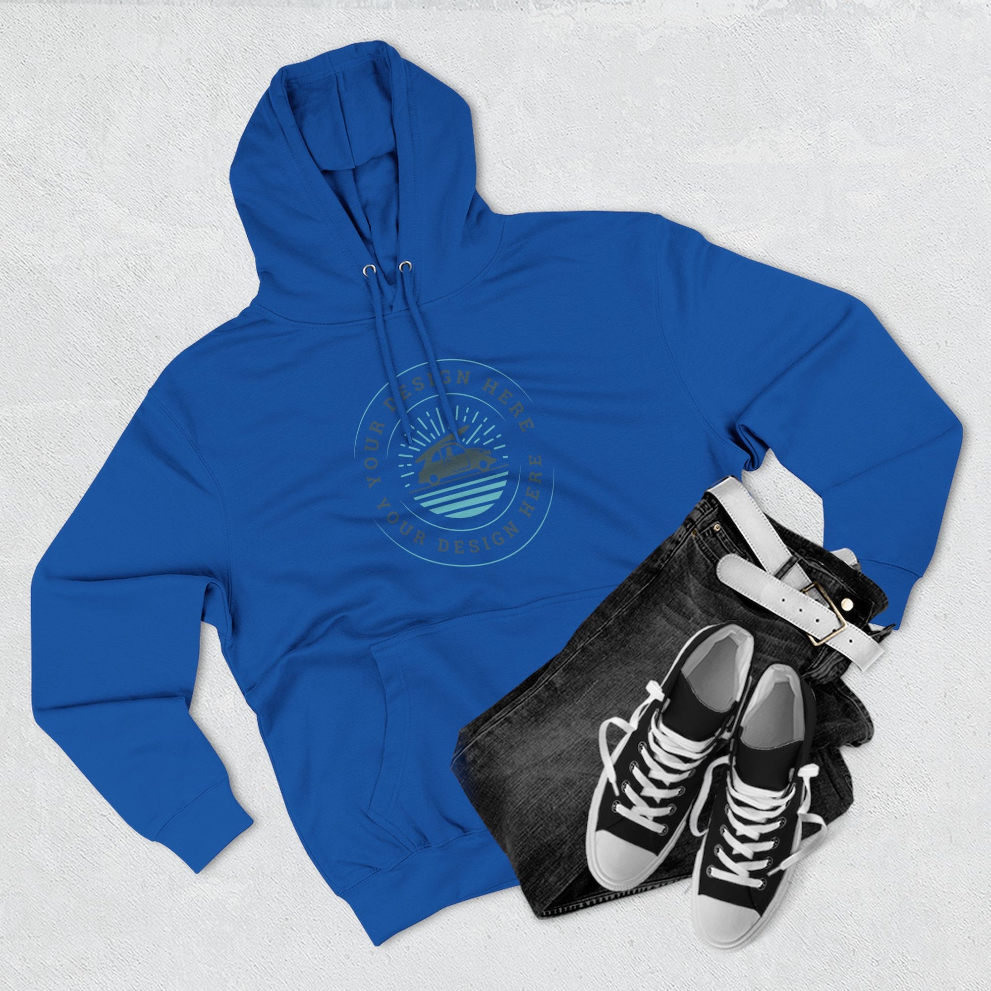 Blue hoodie with a logo, black bag, and black sneakers on a light gray background