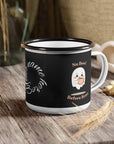 Black mug with ghost design and text on a wooden surface