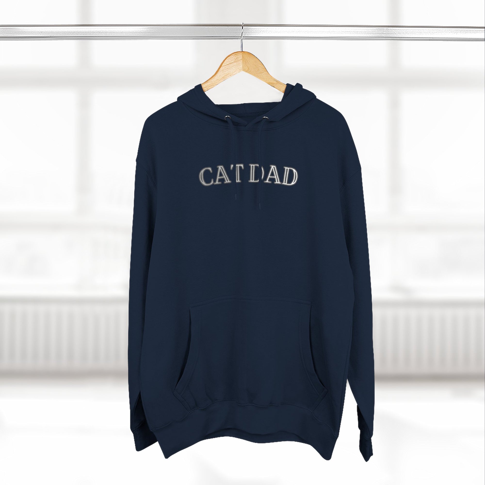 Navy blue hoodie with 'CAT DAD' text on a hanger against a white background