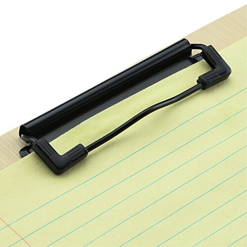 A black plastic clip-on document holder with a curved wire support, shown holding a sheet of lined paper on a light wood surface against a white background.