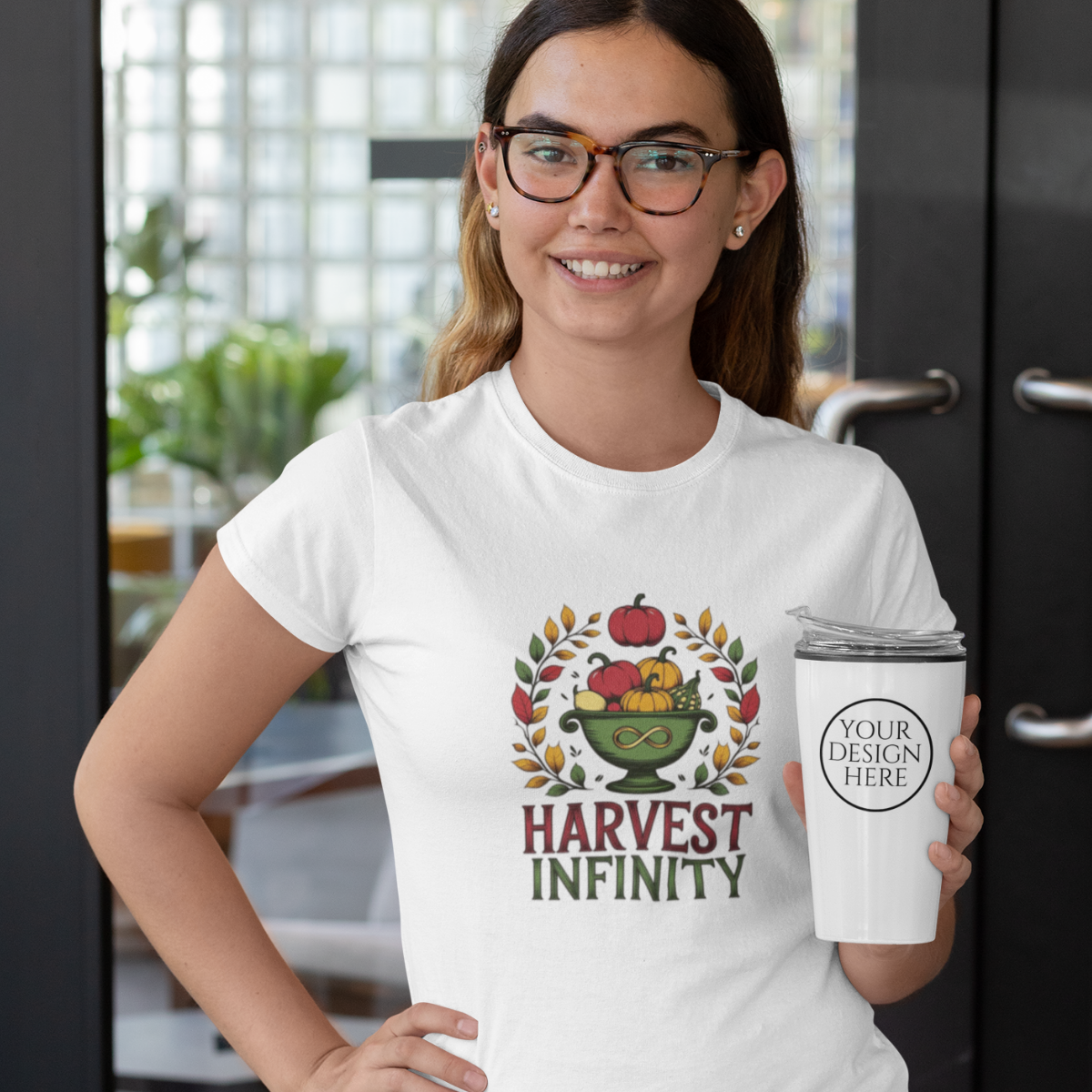 Woman wearing a white t-shirt with 'Harvest Infinity' design and holding a white tumbler.