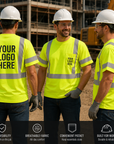 Three construction workers wearing high-visibility yellow shirts with customizable logos on a construction site.